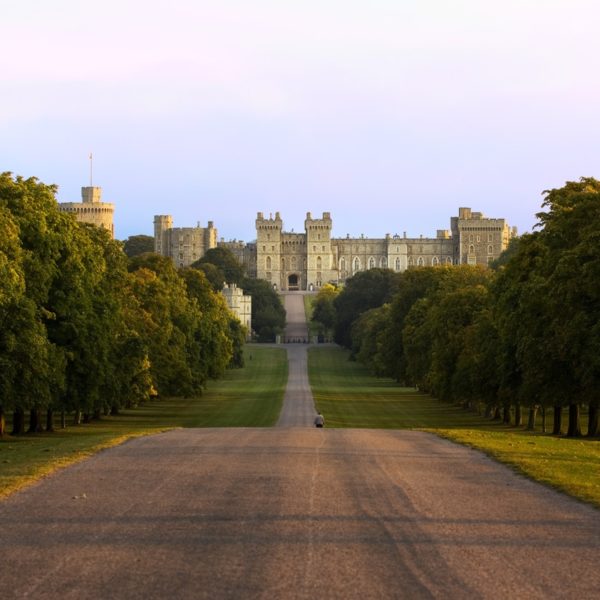 Windsor Castle royal palace military fort British monarch. The Long Walk ceremonial road lined with trees overlooked by the castle on a rise above Windsor Great Park.